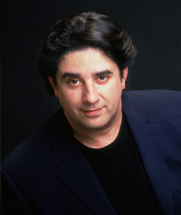 A man in a suit smiles at the camera