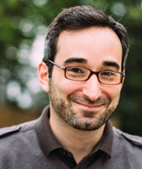 man with brown hair, beard and glasses