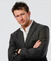 A man in a striped suit looks at the camera.