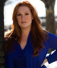 A woman wearing a blue shirt looks at the camera.