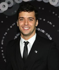 A man in a suit smiles at camera.