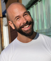 A man with a beard smiles at the camera.