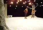two actors conversing on a snowy set with trees