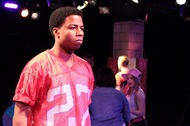 actor in a red football jersey is looking to the right
