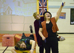 actor reaching to the sky with two actors peering