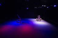 one lit spot on stage with a chair
