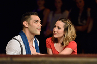 two actors speaking intimately, the male actor is looking out and the female actor is looking at the male