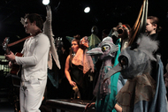 actors lined up, some are dressed as stone birds