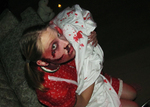 a bloodied actor holding up a blood splattered cloth