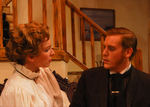 two actors sitting in a living room, looking into each other's eyes