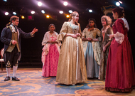 five actors dresses in puffy, big dresses while a male actor enters from the left