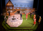 actors standing in a garden in front of a balcony