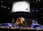 actor sitting on a carriage while talking to an actor standing next to him