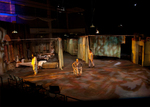 stage divided into two rooms and a hallways, actors are in their respective rooms