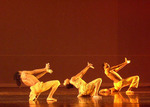 three dancers on one leg and holding both hands together and leaning backward