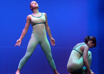 dancer looking up while a dancer next to them in hunched down