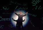 actor standing in front of a projected image with a light shining on them