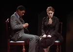 two actors sitting in separate chairs, looking down at their own laps