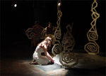 an actor on their knees with a dim light shining on them