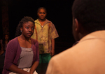 an actor have a serious conversation with another while another actor in the background watches