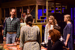 actors standing at a dining table having a discussion