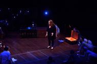 an actor standing in the center of the stage, looking out