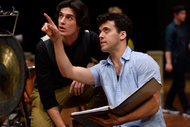 a man holding a book and pointing up, another man is looking where he is pointing