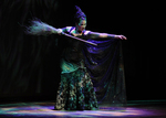 actor playing a witch pointing while holding a broom