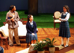 an actor standing with arms crossed while two others look at her