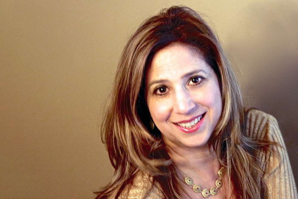 A portrait of a smiling woman with long hair.