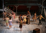 actors dancing around a tavern set