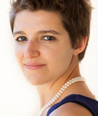 woman with short brown hair and pearl necklace