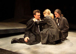 three people in black robes onstage