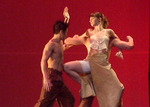 a dance holding a female dance on his back and another dancer approaching the female