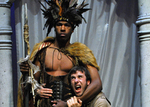 an actor dressed as a warrior holding the head of another actor in his left arm