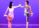 two dancers holding each other's hand, they both have one leg in the air