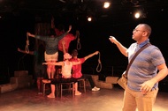 actors standing in a formation with nooses hanging from their arms