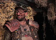 close up picture of an actor looking to the left and wearing rustic, steampunk clothing
