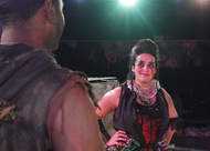 a female actor with painted face and steampunk clothes looking at someone