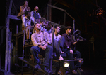 group of actors sitting along a spiral staircase