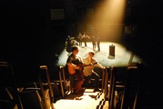 an actor running up to another actor singing with a guitar