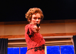 actor in red pointing a gun at the camera
