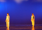two dancers dressed in the same clothes standing on opposite sides of the stage