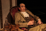 a male actor is sitting in a chair, relaxing