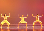 three dancers lined up with their legs spread and bent, their arms matching