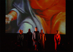 dancers standing onstage with an image displayed behind them