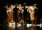 dancers standing in a circle, while light shining in the center
