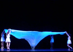 dancers holding up large cloth which is attached to the center of the stage