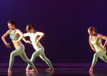 three dancers, knees bent, with their arms hovering by their hips, as if they are charging up