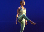 close up of a dancer standing on one leg, her leg is bent and out in front of her